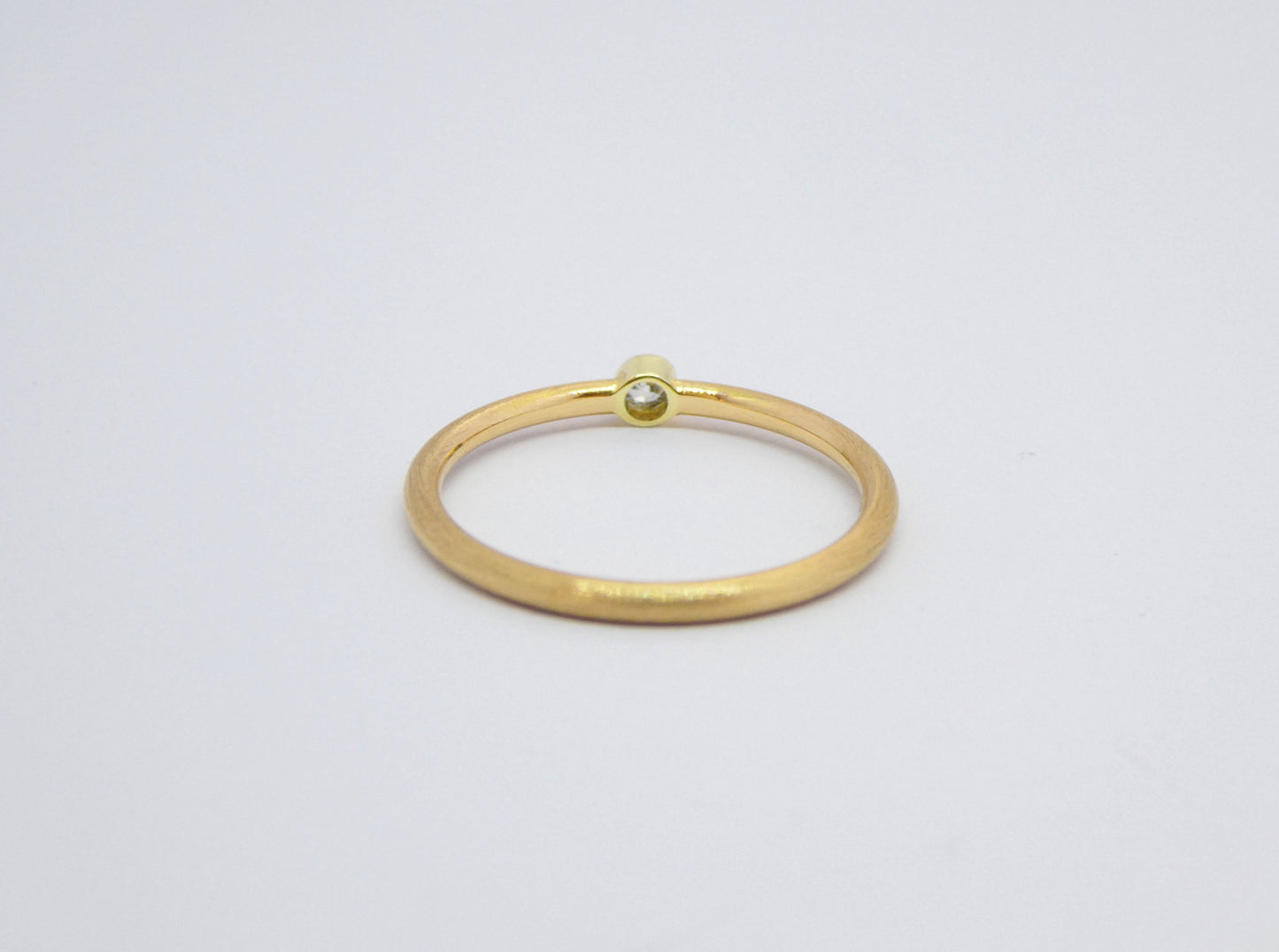 schmaler handgearbeiteter Goldring mit Diamant