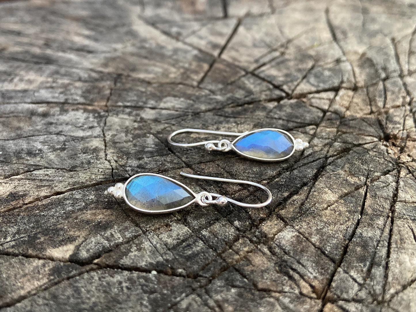 Simple earrings made of silver with faceted labradorite stone in the shape of a teardrop