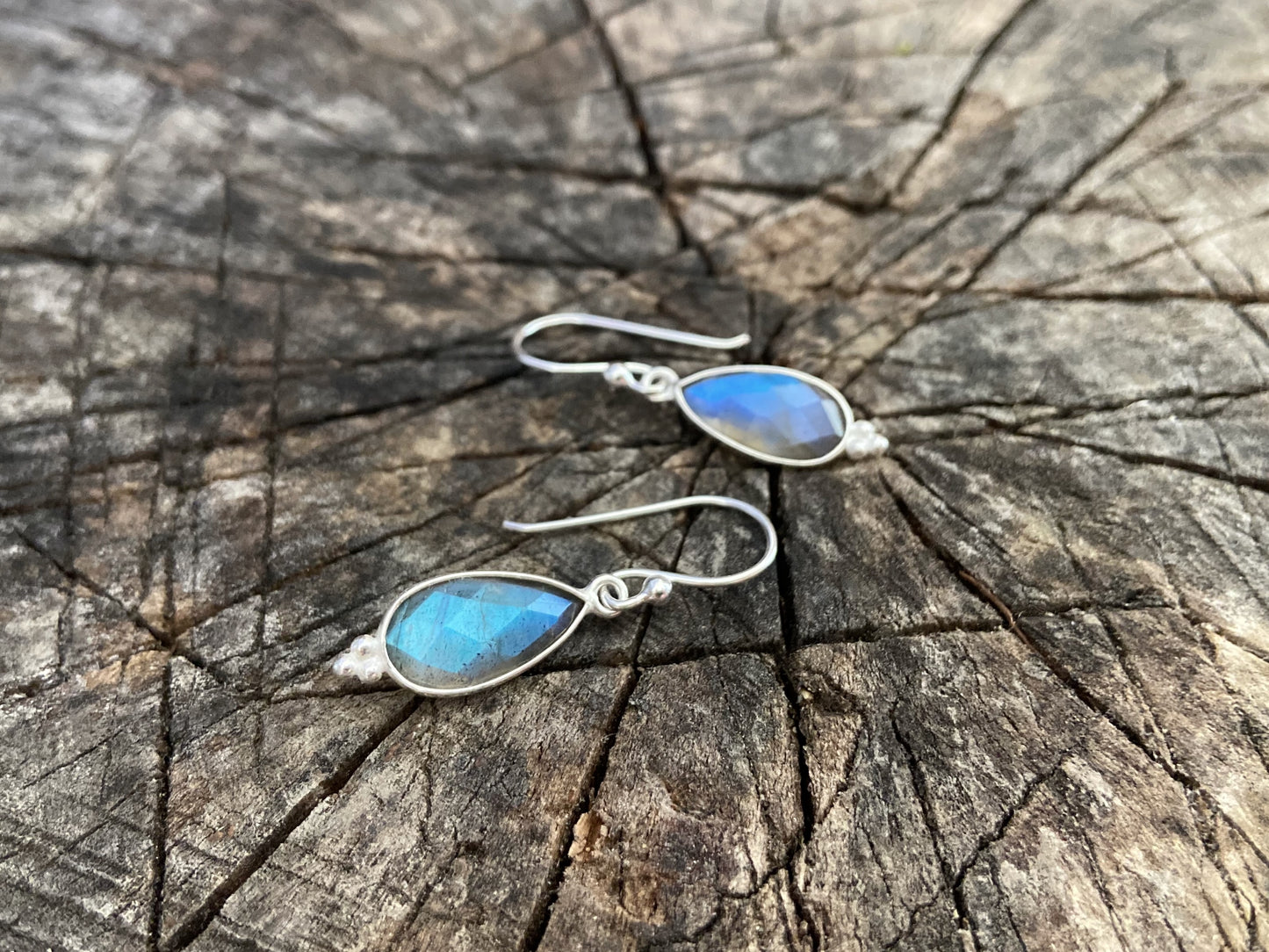 Simple earrings made of silver with faceted labradorite stone in the shape of a teardrop
