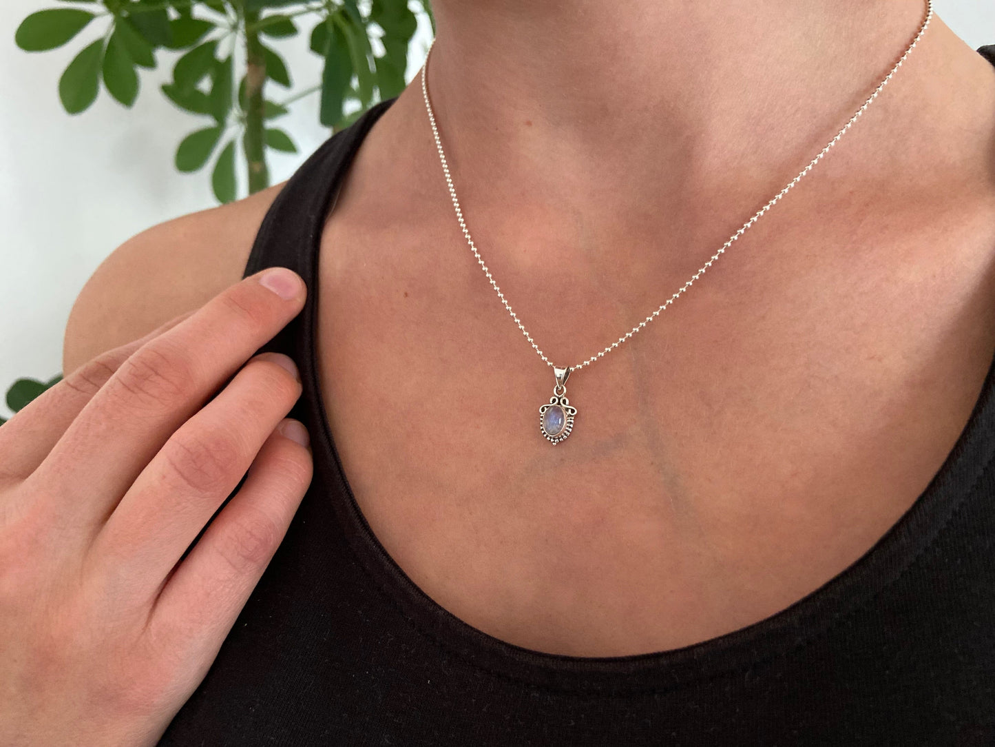small pendant with floral pattern and stone made of silver