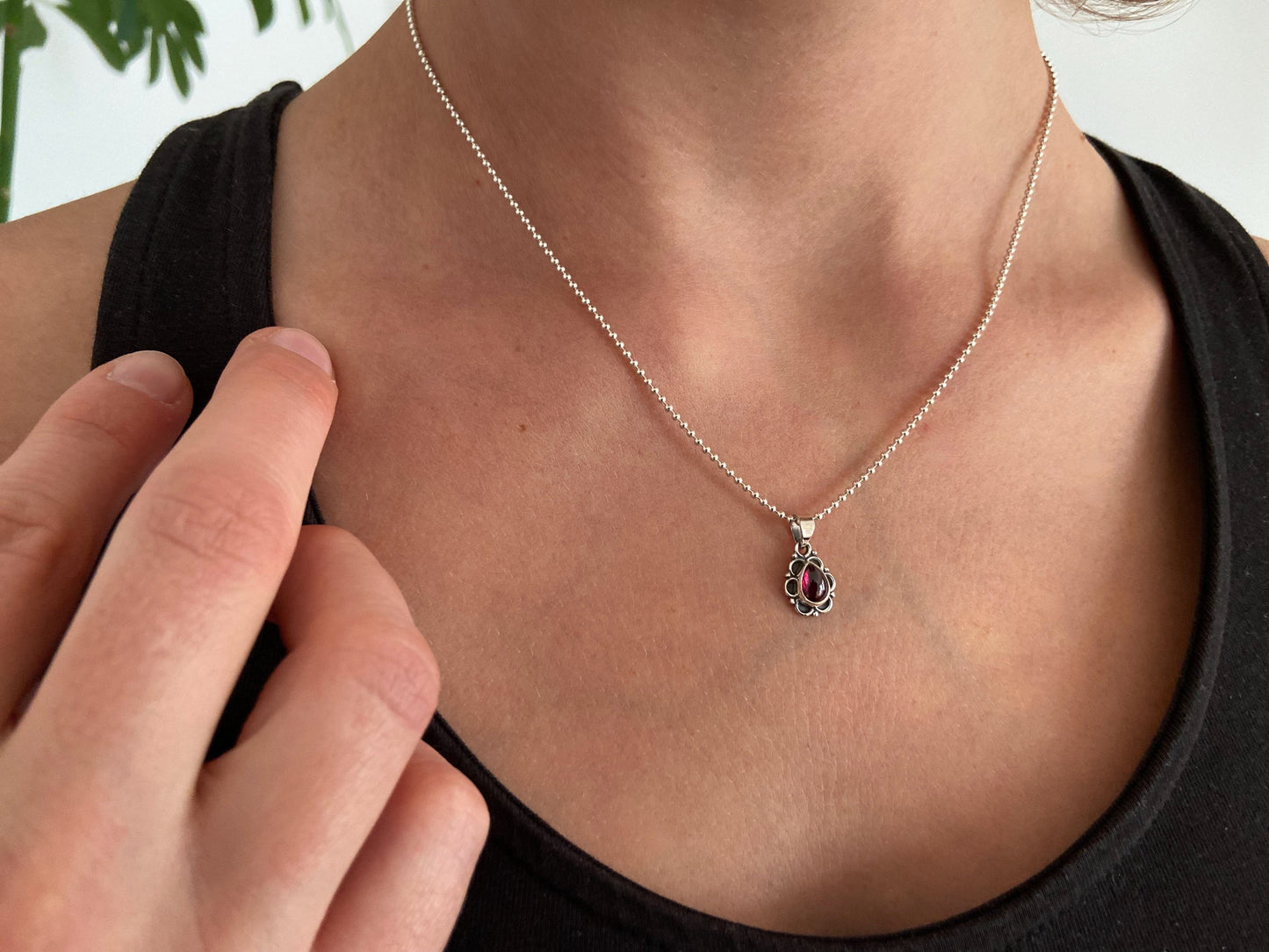 small pendant with floral pattern and stone made of silver