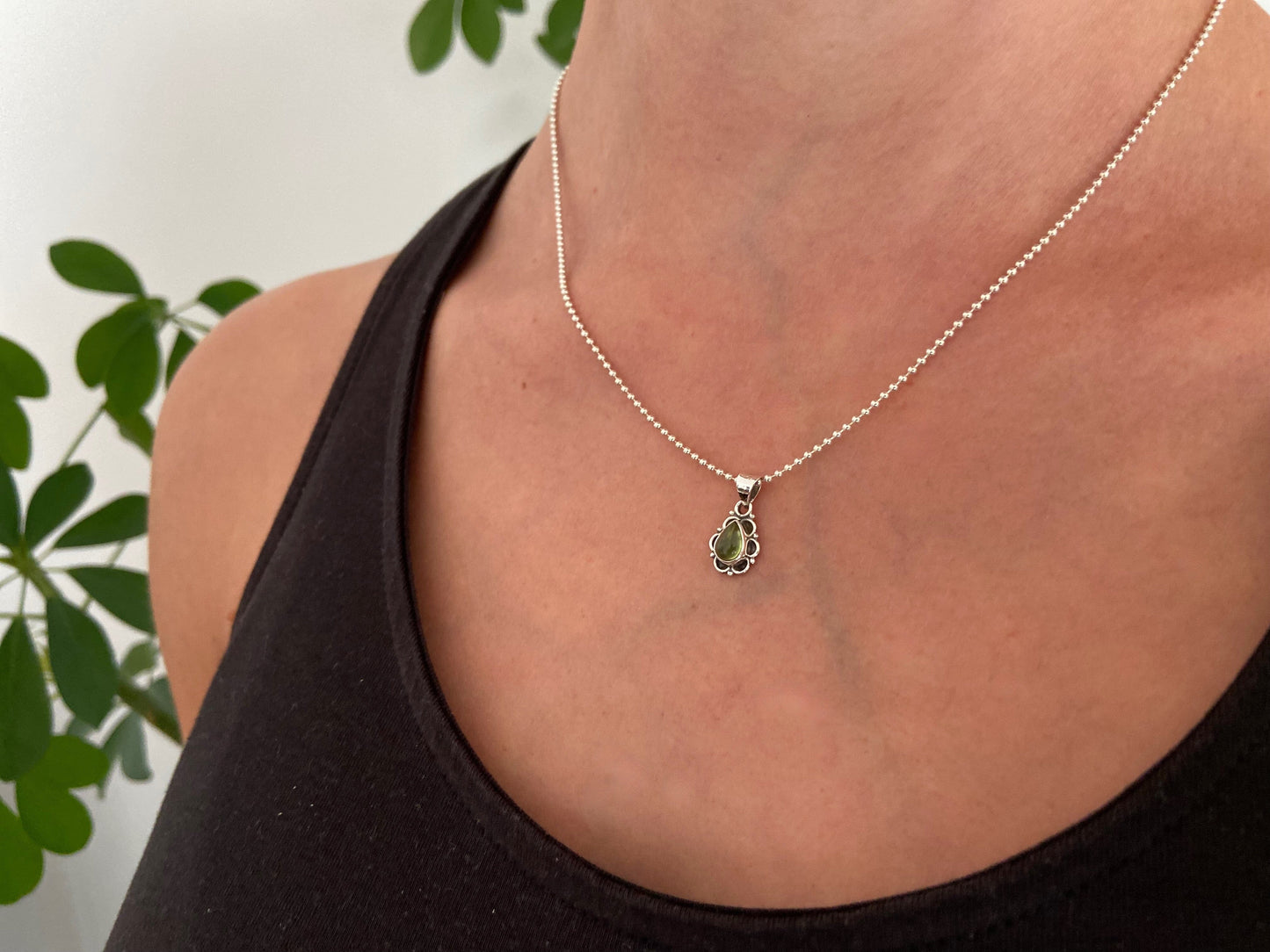 small pendant with floral pattern and stone made of silver