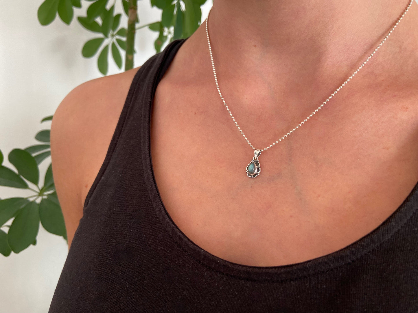 small pendant with floral pattern and stone made of silver