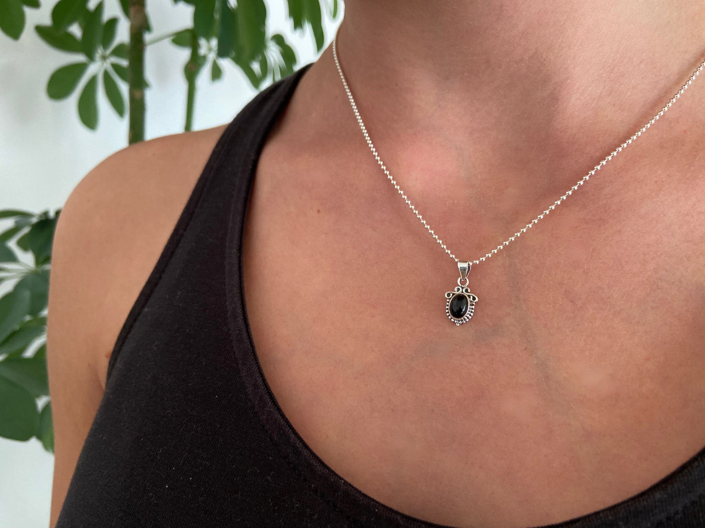 small pendant with floral pattern and stone made of silver