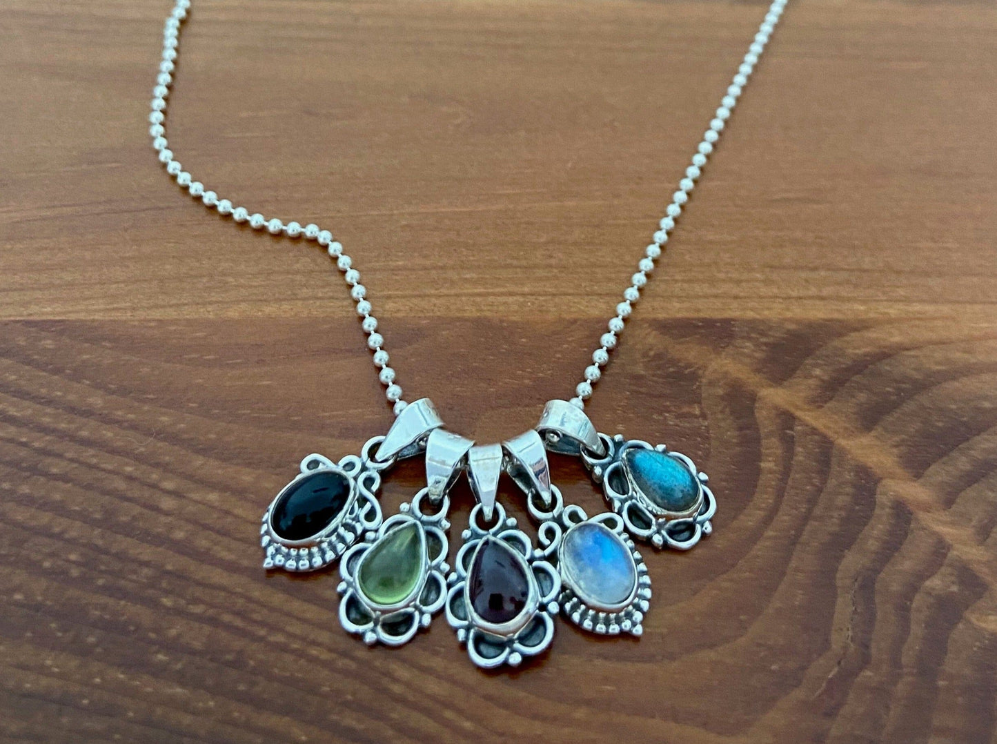 small pendant with floral pattern and stone made of silver