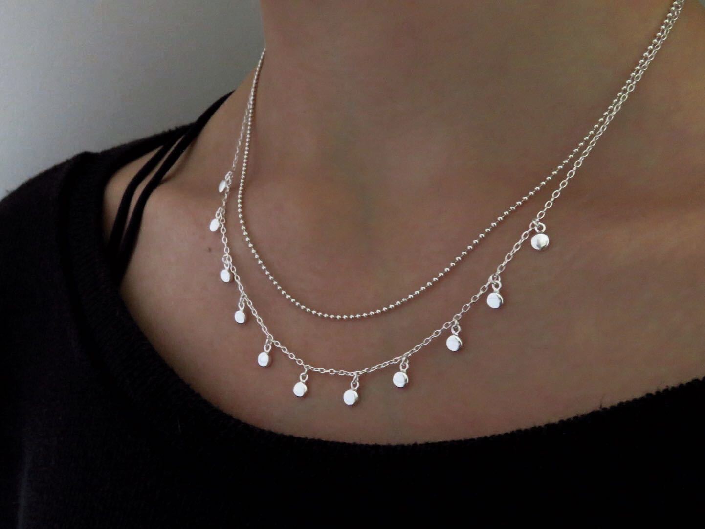 Kette mit kleinen baumelnden runden Anhängern aus Silber