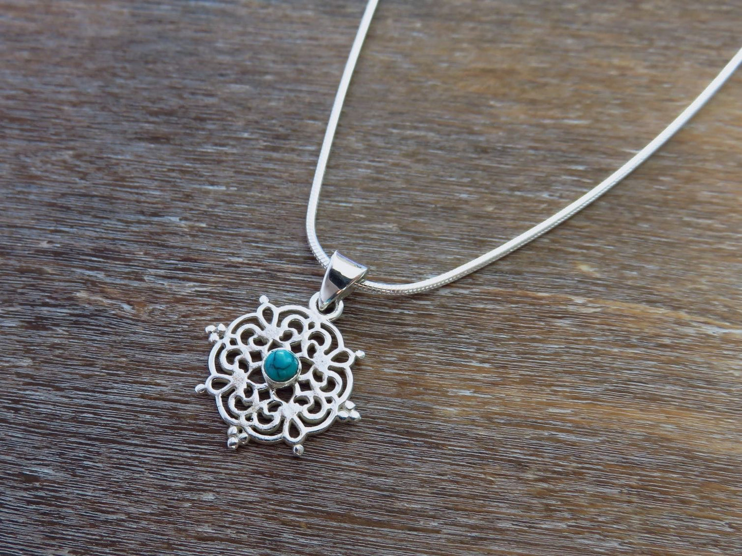 small filigree pendant with turquoise stone made of silver