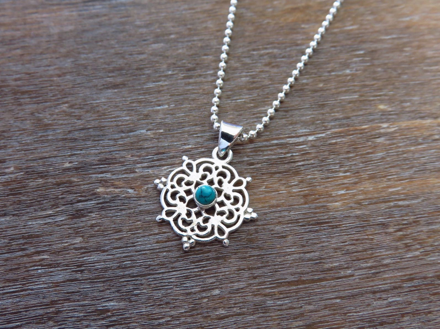 small filigree pendant with turquoise stone made of silver