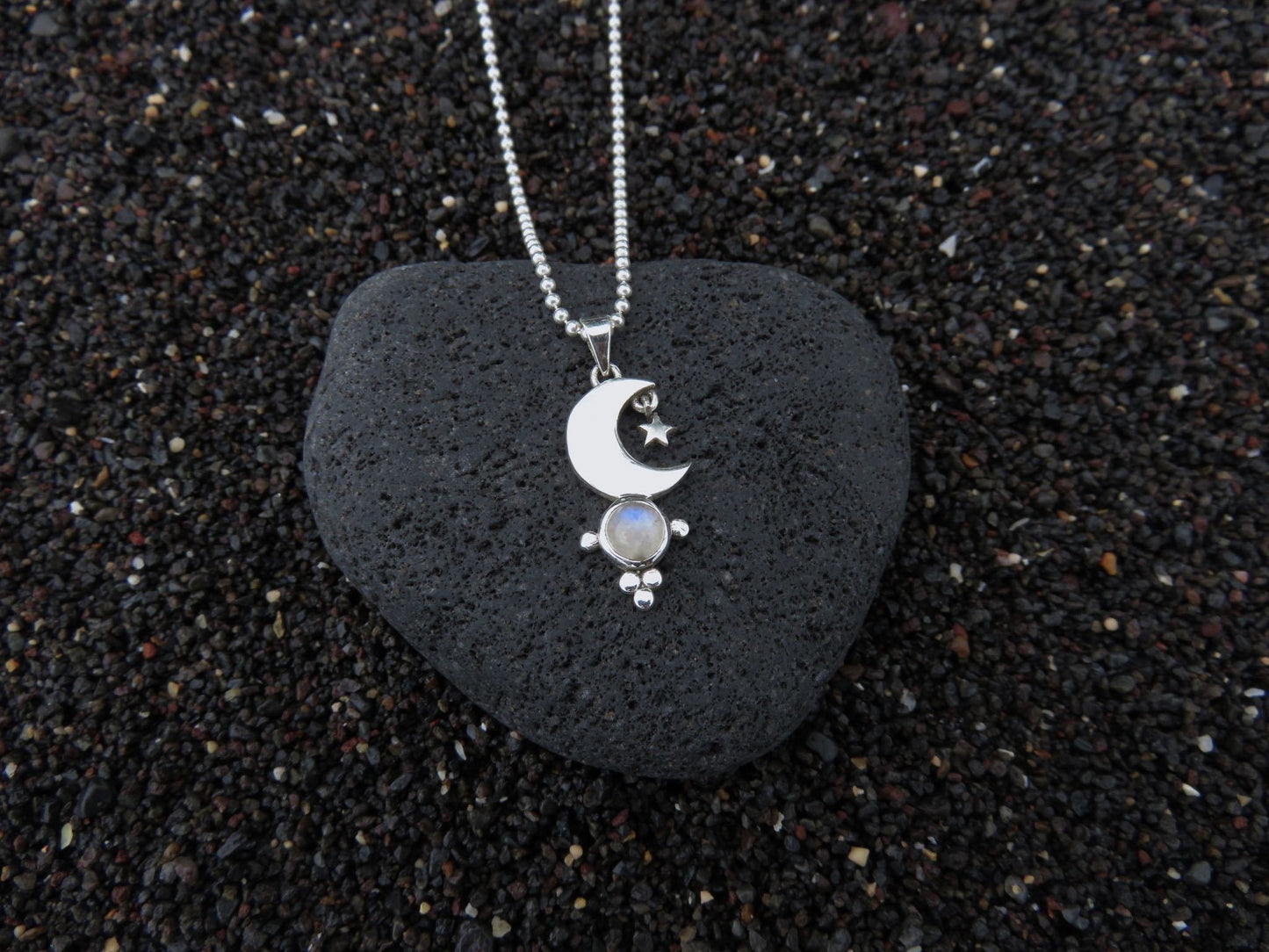 small pendant with moon and stars on a silver ball chain