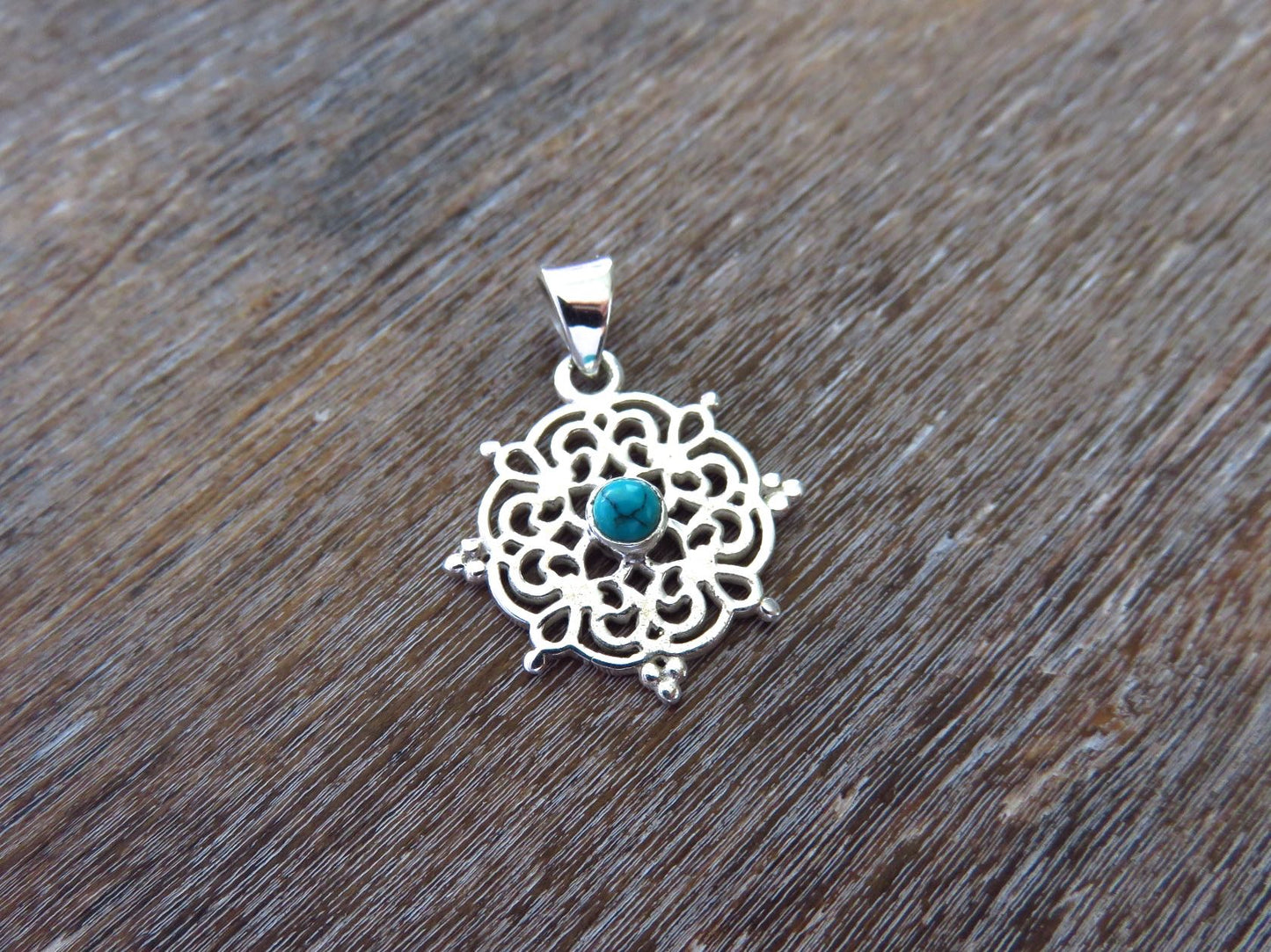 small filigree pendant with turquoise stone made of silver