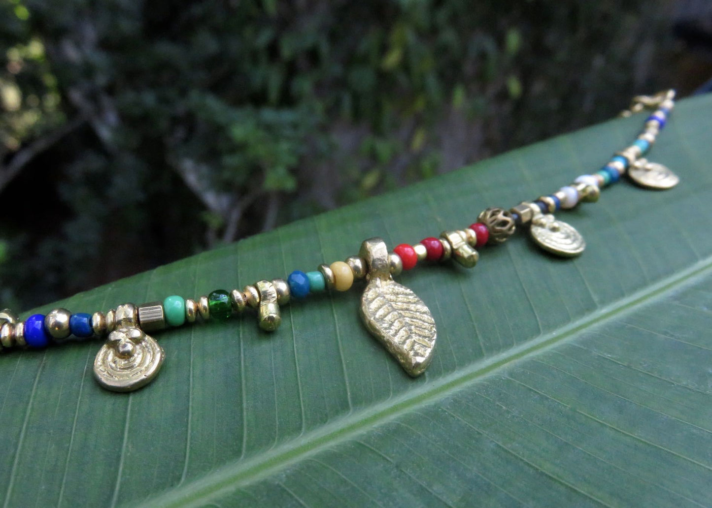 buntes Armband mit kleinen Anhängern und Messingperlen