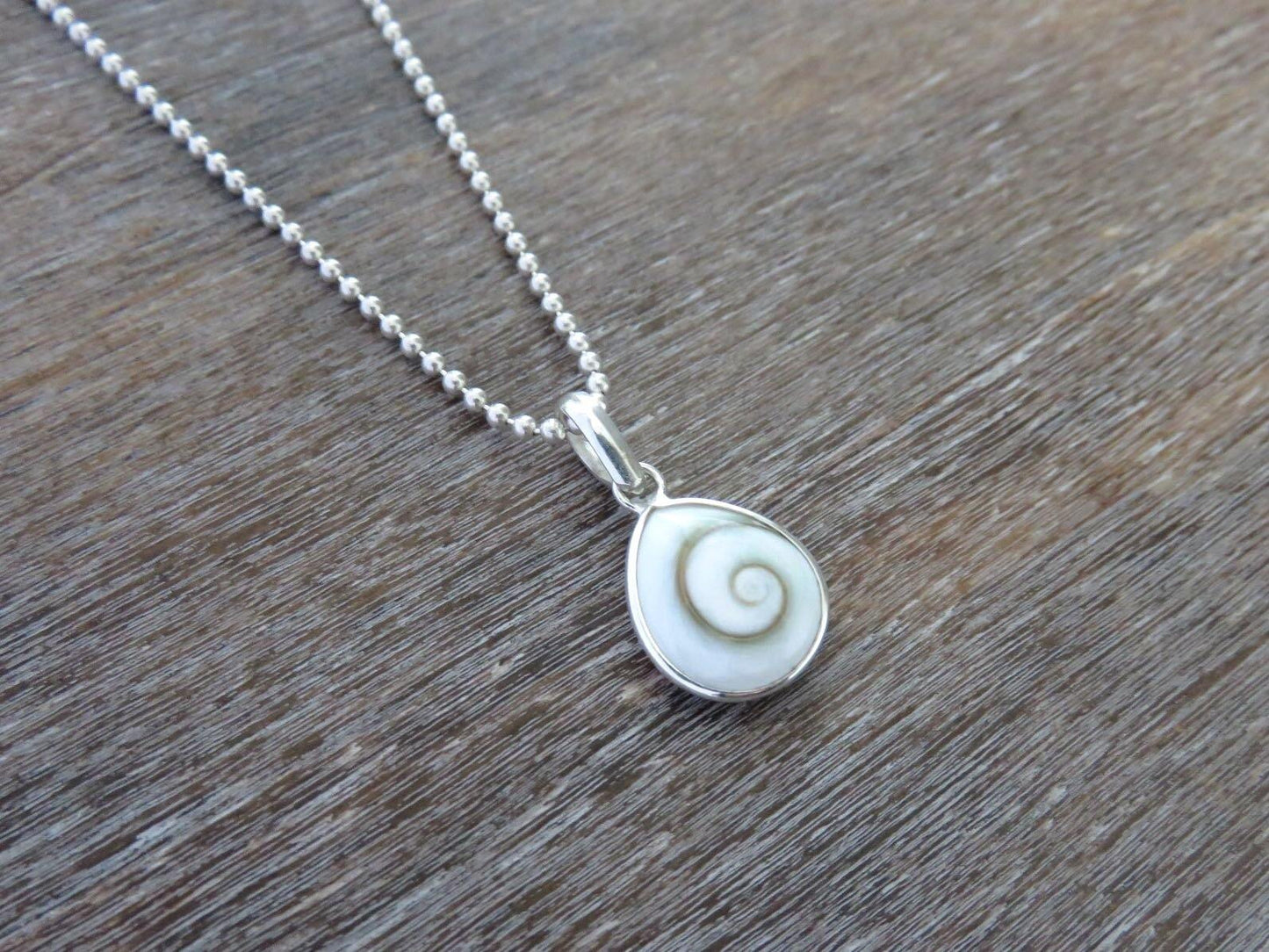 small teardrop-shaped operculum pendant made of silver