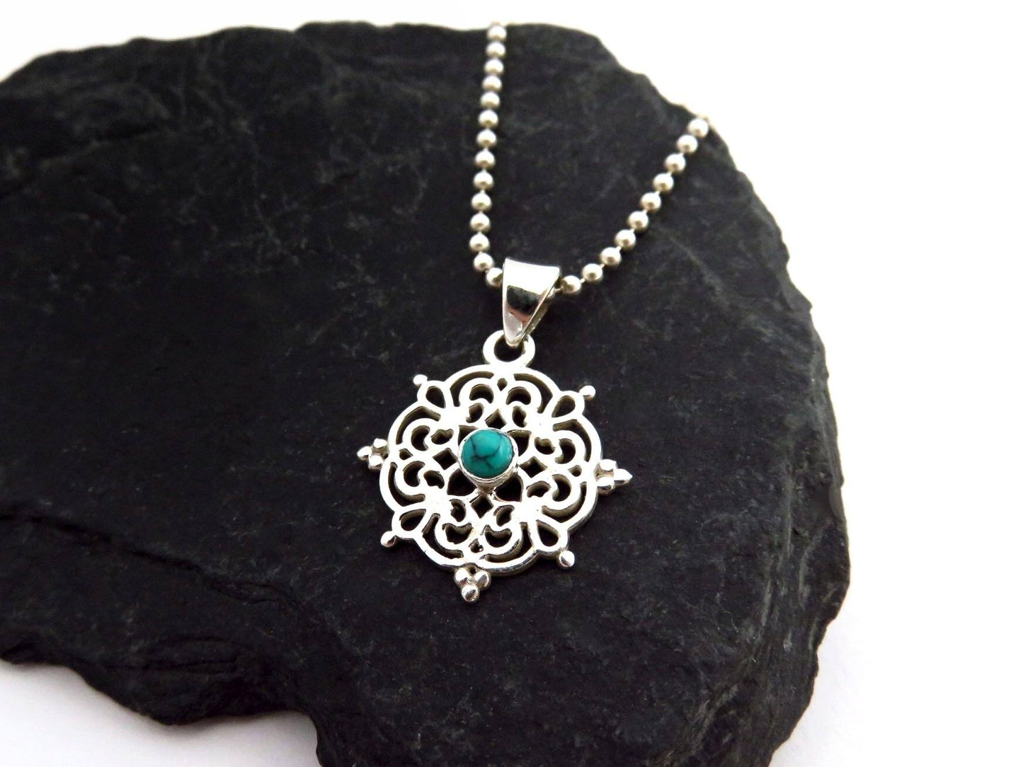 small filigree pendant with turquoise stone made of silver