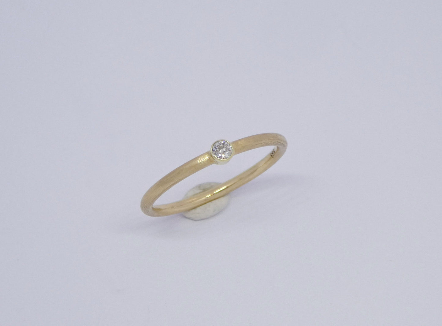 schmaler handgearbeiteter Goldring mit Diamant