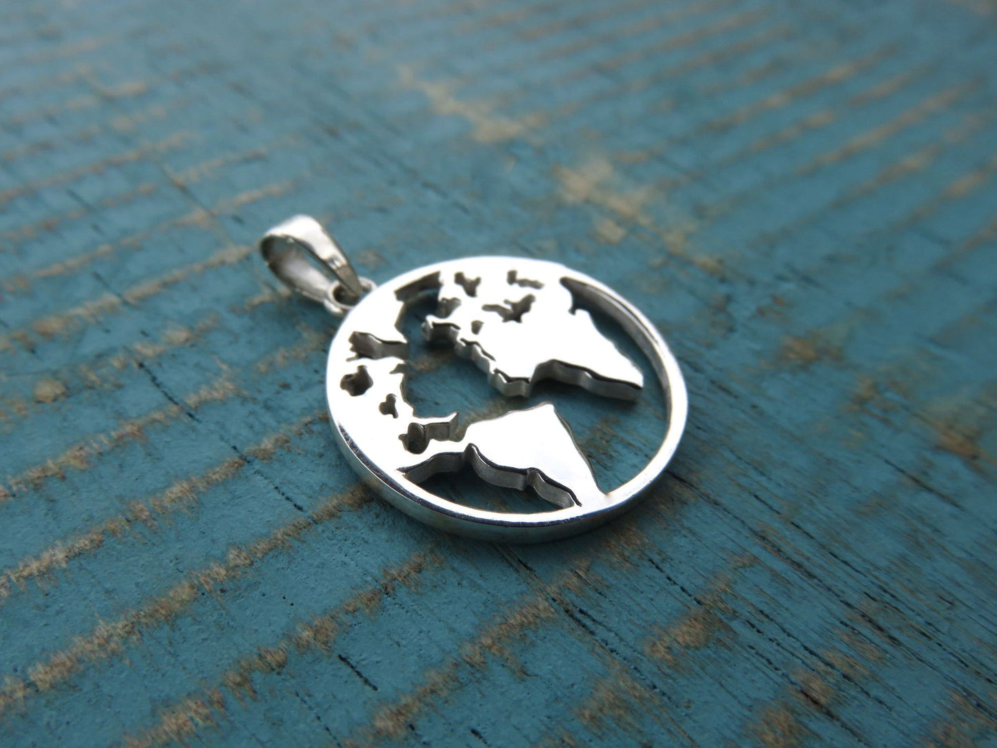 Silver world map pendant for travel lovers