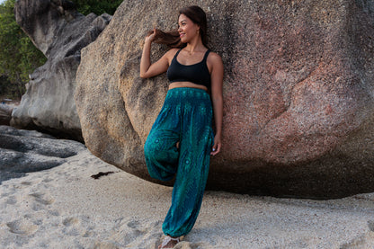 Airy harem pants with a peacock pattern in turquoise