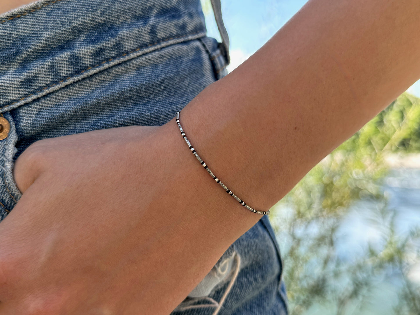 zartes geknotetes Armband mit kleinen gemusterten Perlen aus Silber