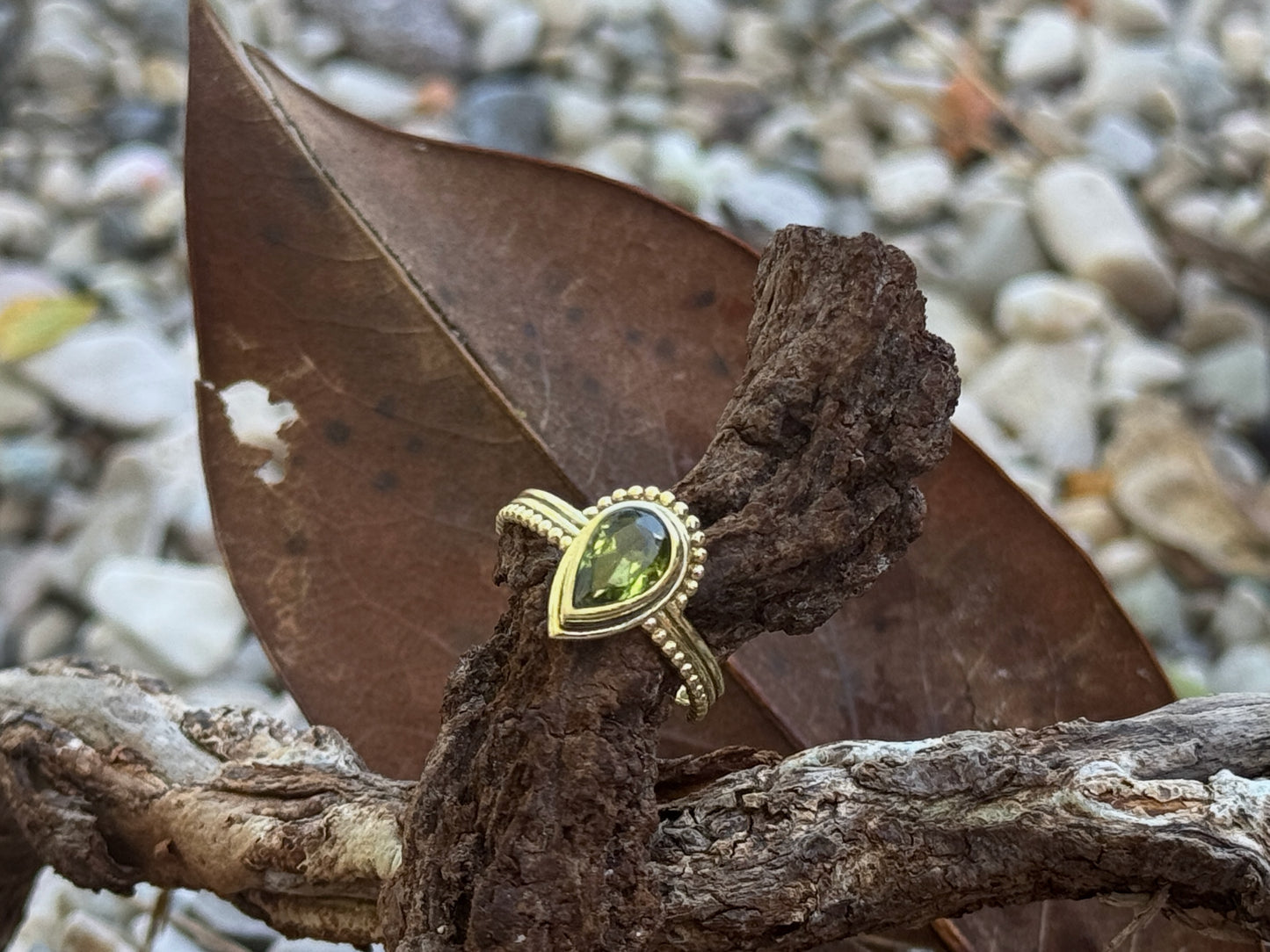 Ring mit facettiertem grünen Peridot in Tropfenform aus Messing