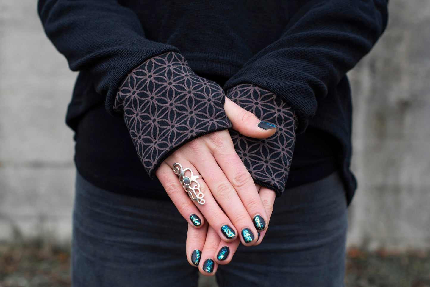 long knitted sweater with a patterned hood and thumbholes in black 