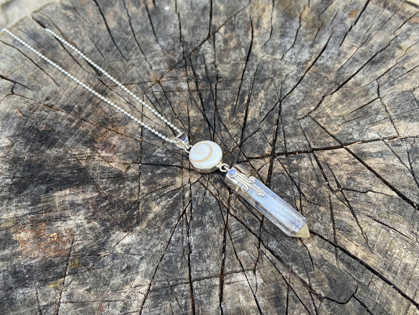 Pendant rock crystal with operculum with spirals, dots and small stone, silver 