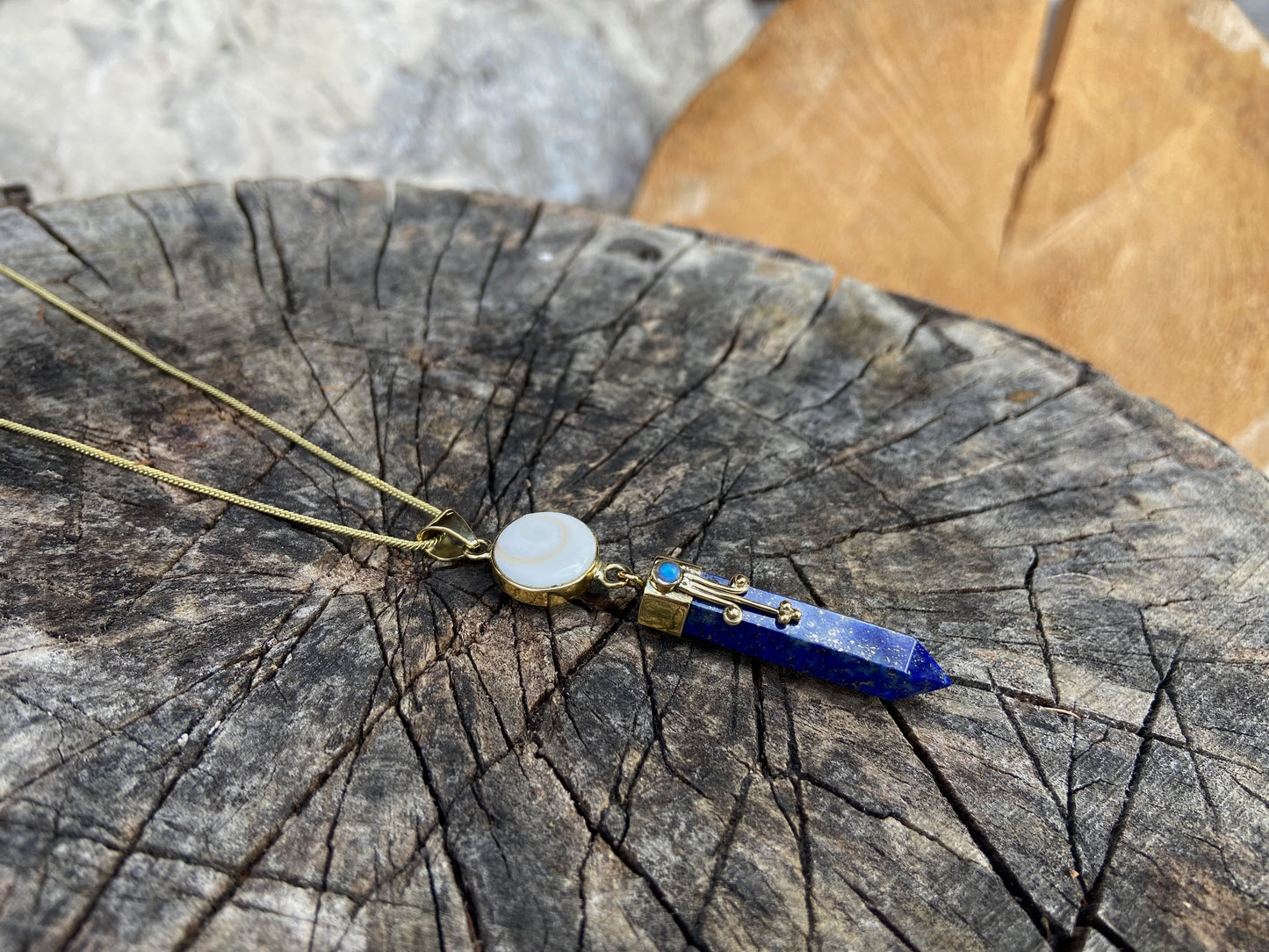 Anhänger Lapis Lazuli mit Operculum mit Spiralen, Pünktchen und kleinem Stein, Messing