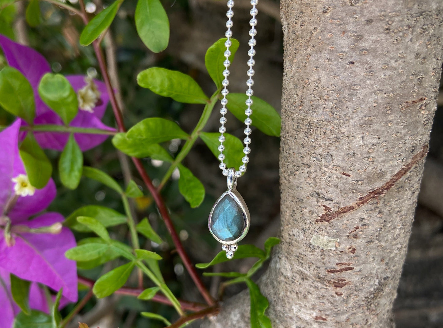 small silver pendant with tropical-shaped faceted labradorite stone 