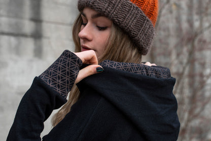 half-length knitted sweater with a patterned hood and thumbholes in black 