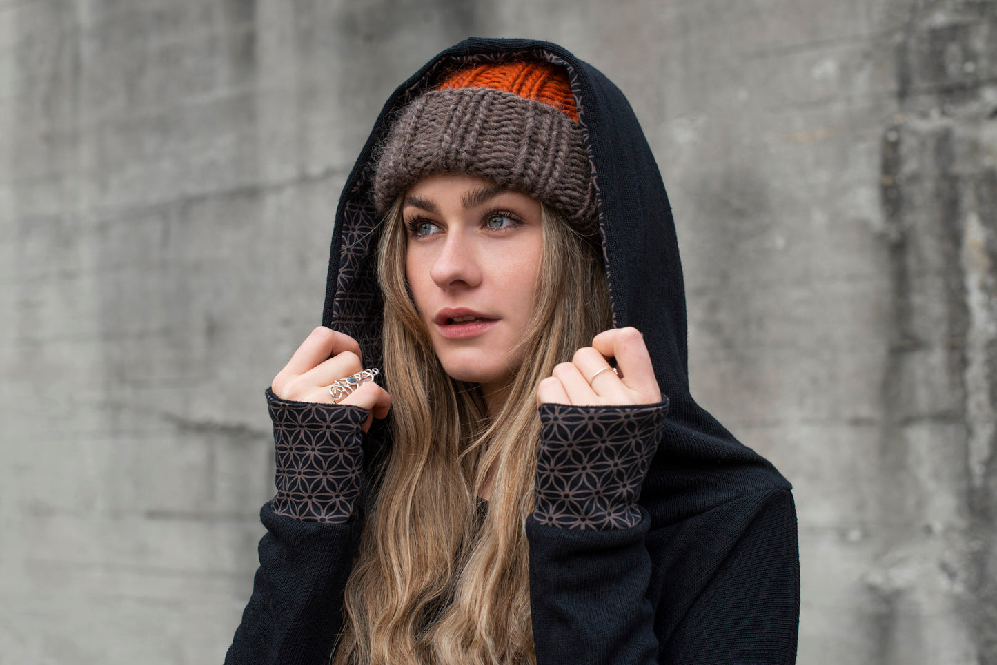 half-length knitted sweater with a patterned hood and thumbholes in black 