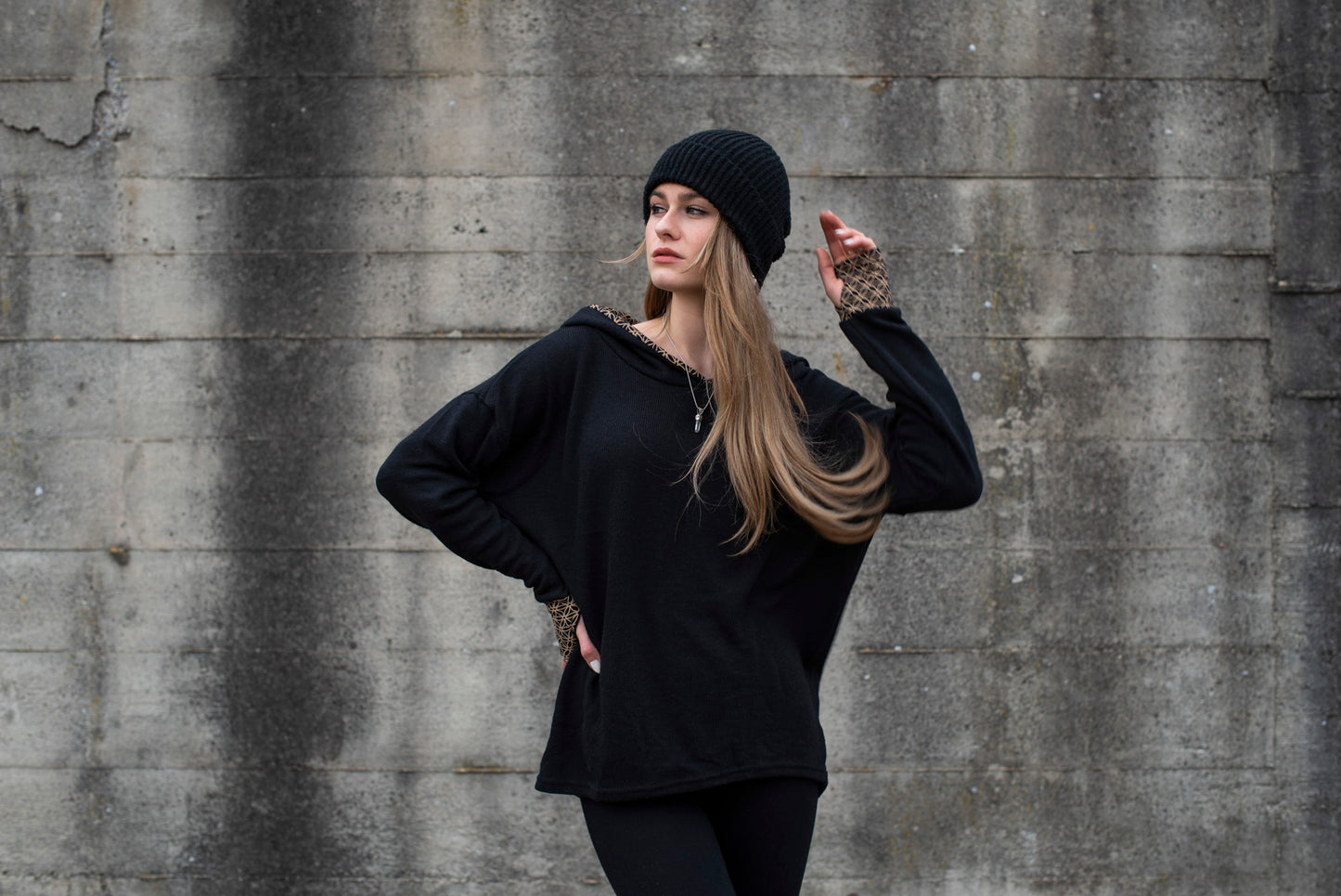long knitted sweater with a patterned hood and thumbholes in black 