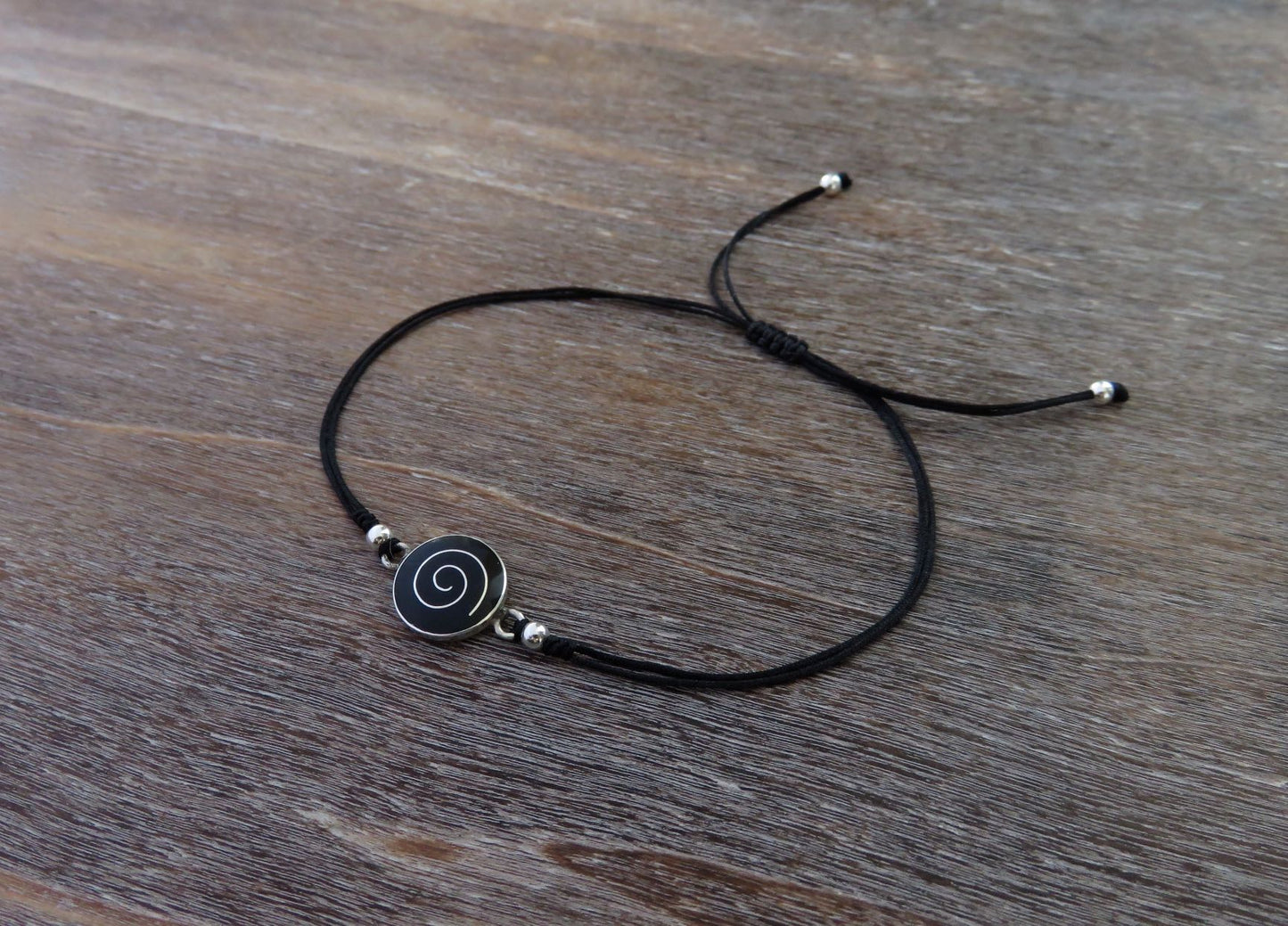schwarzes Armband mit Spirale und Perlen aus Silber