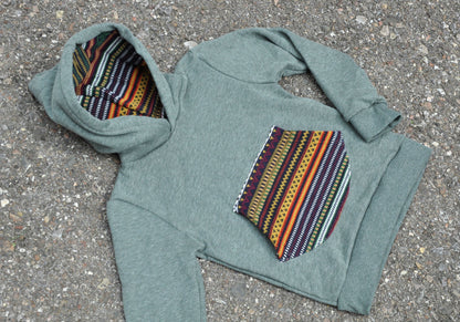 Children's sweater with colorful pocket and green hood lining 